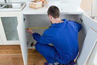 man fixing a kitchen cabinet